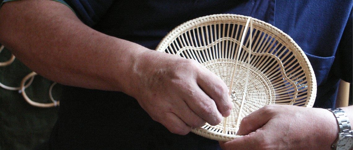 Person beim Flechten eines Korbes